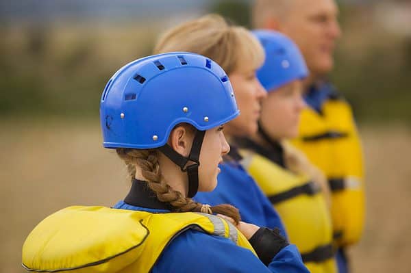 Girl ready to raft wearing helmet and life vest