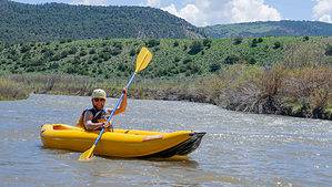 Man paddling inflatable kayak