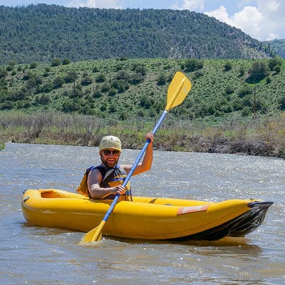 Man paddling inflatable kayak