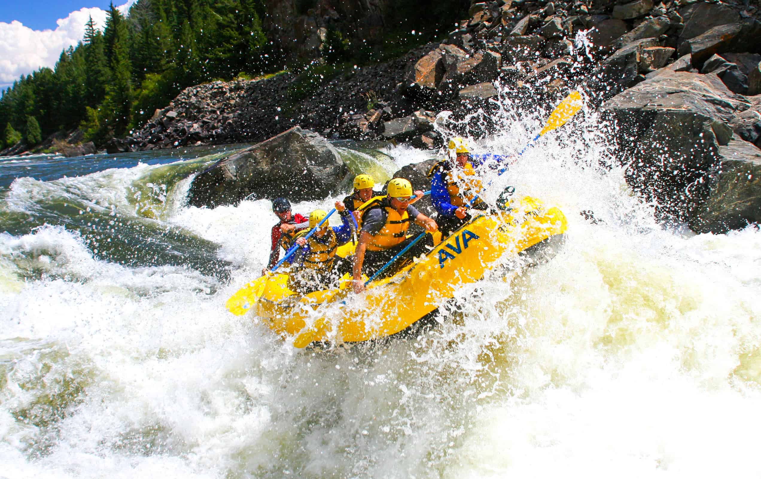 A group of rafters smash into a wave of whitewater