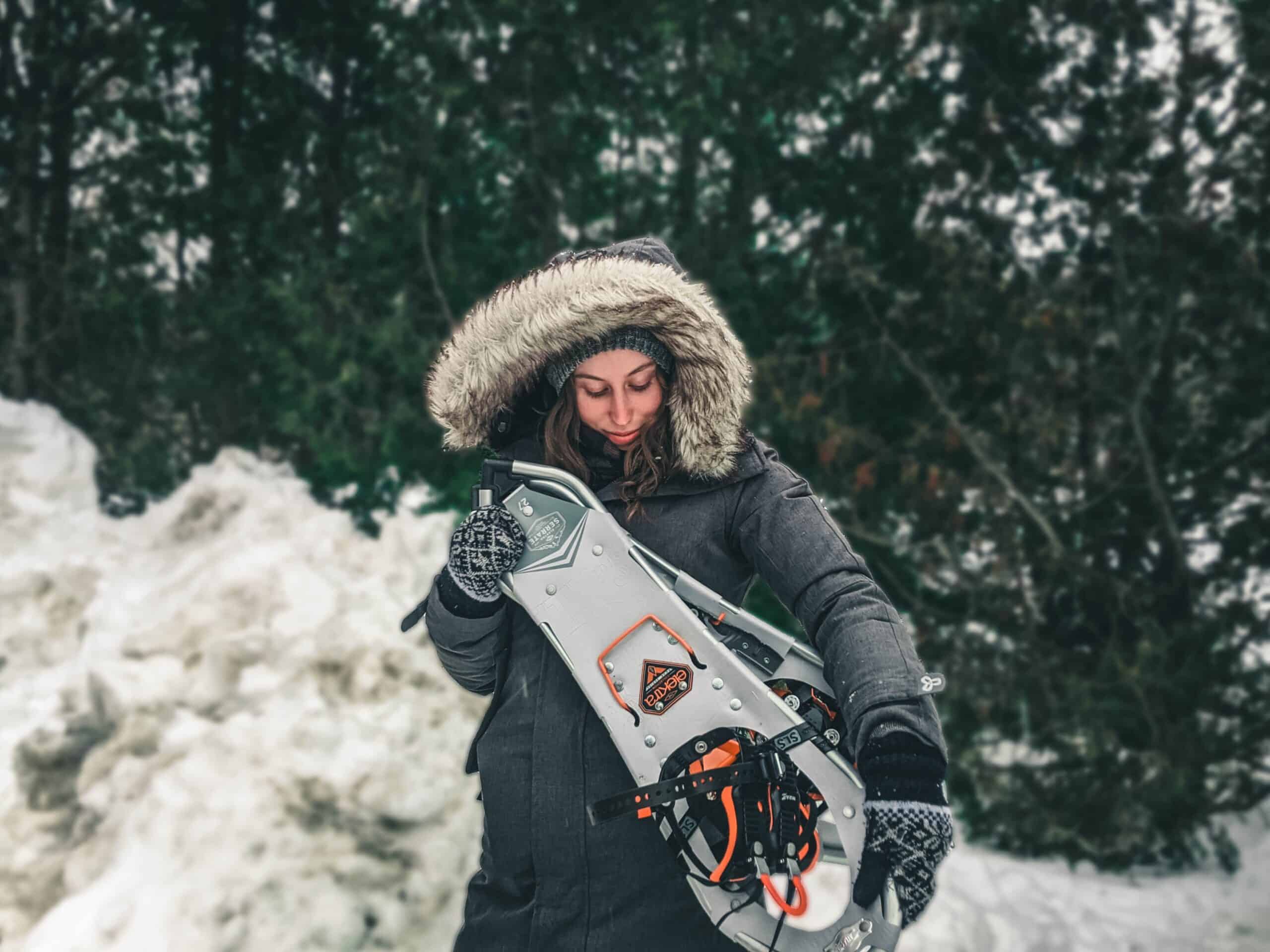 Woman holding snowshoes winter