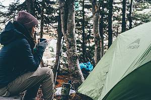 woman drinking coffee outside tent