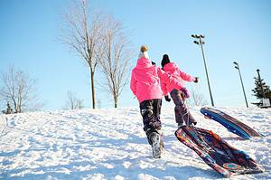 Two girls sledding