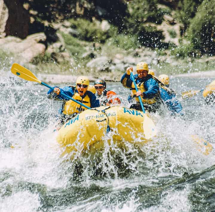 Whitewater rafting trip, group battling spray