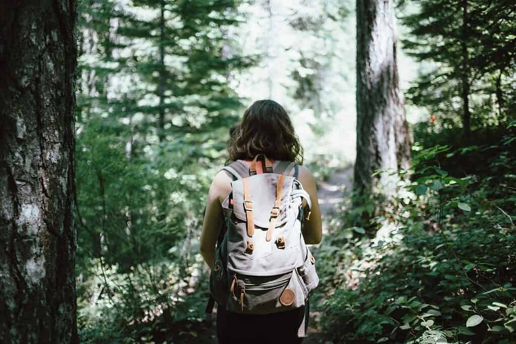woman hiking in woods with backpack