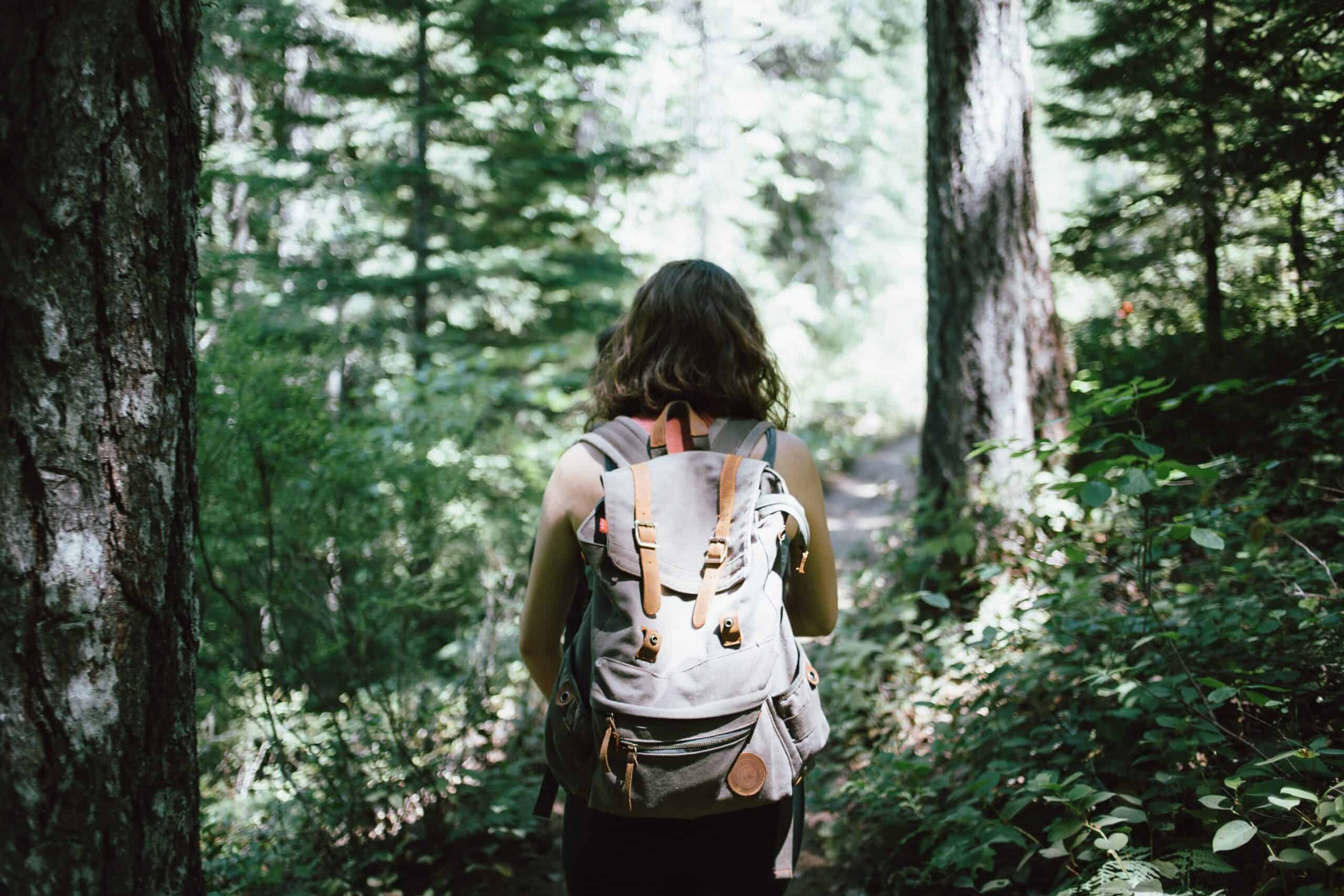 woman hiking in woods with backpack