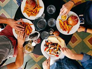 people sitting at table eating food