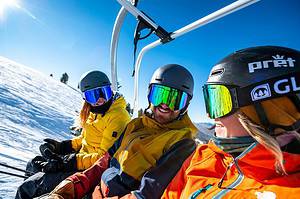 three skiers on chairlift