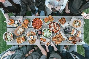 group around table with trays of food