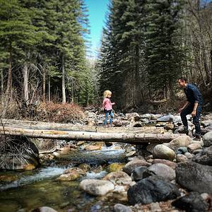 dad watching daughter cross stream